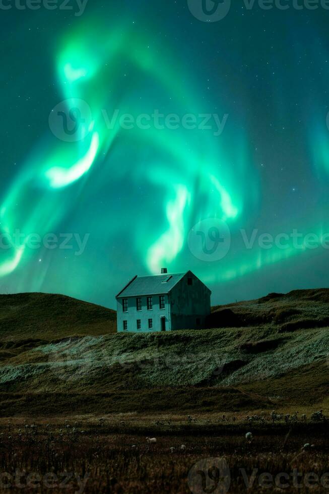 aurore borealis et étoilé plus de nordique maison sur colline parmi le champ dans le nuit à Islande photo