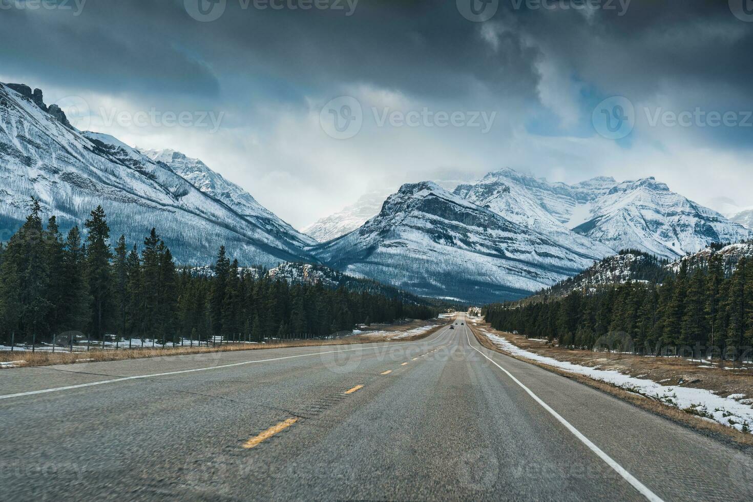 Autoroute route sur le champs de glace promenade avec rocheux montagnes et pin forêt dans hiver photo