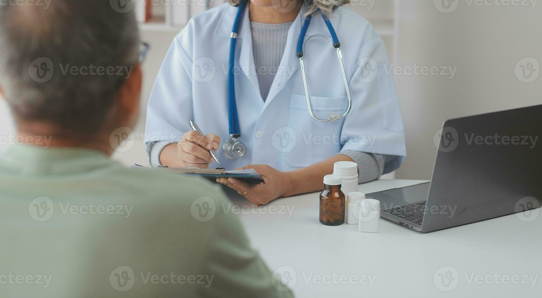 mature asiatique Masculin médecin parlant avec le sien patient, expliquant le procédure à vieux dame. photo