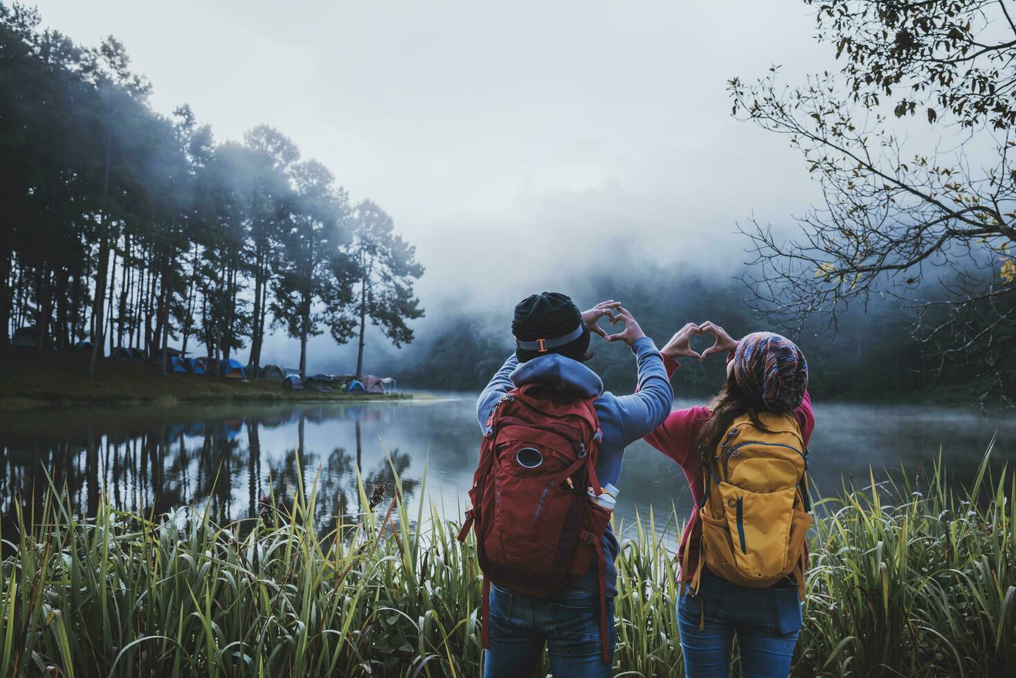 Les amoureux de couple voyagent avec une belle vue panoramique sur la nature du lac pang ung dans la brume au lever du soleil, province de mae hong son, thaïlande. photo