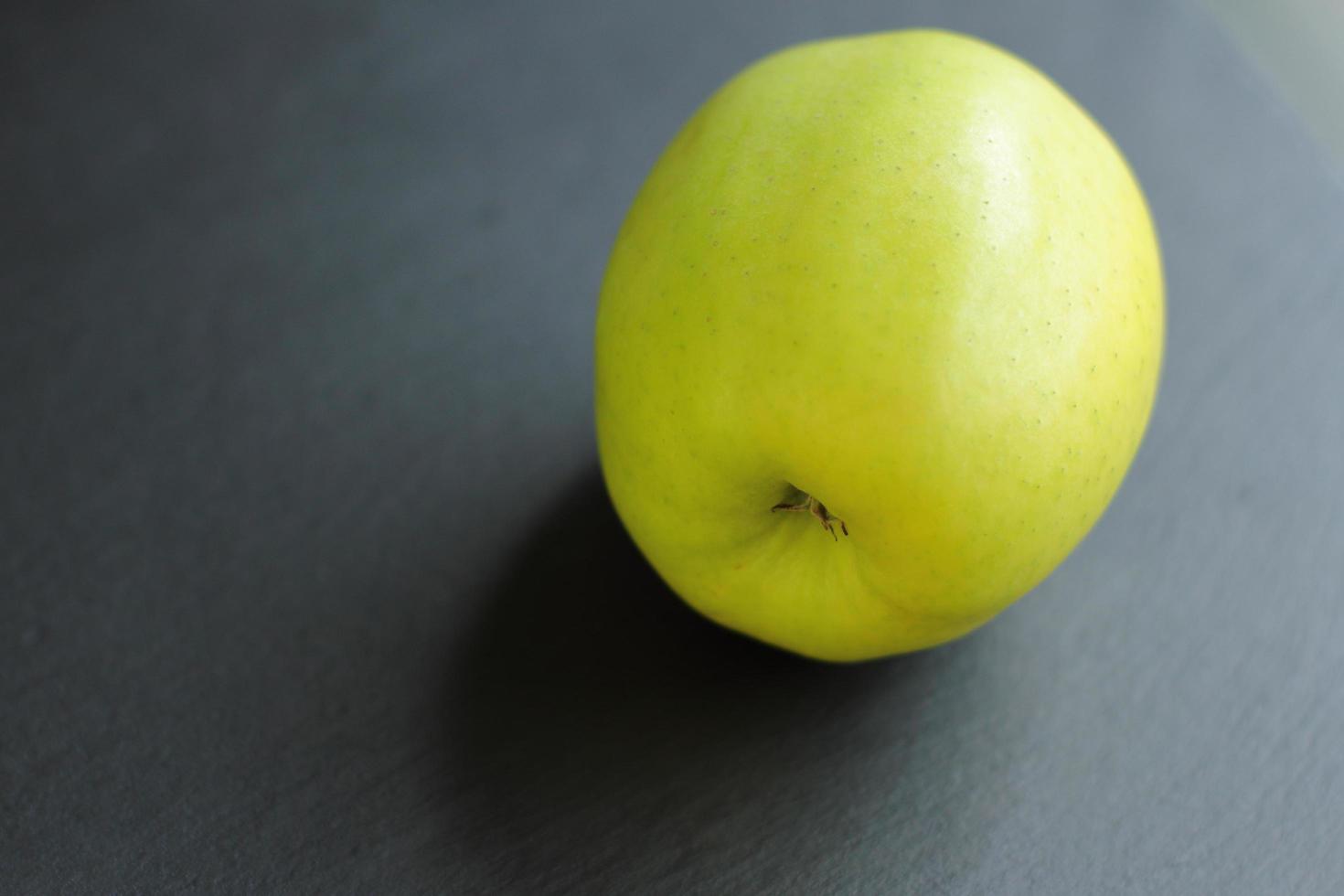 pomme crue verte sur fond noir photo