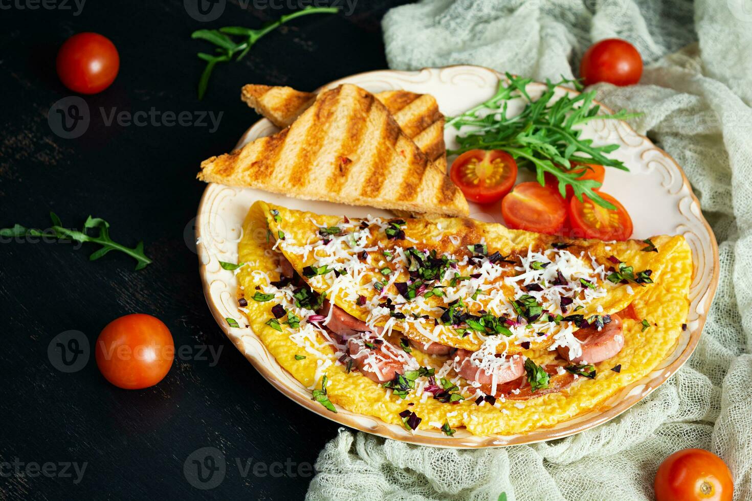 frit omelette farci avec saucisse, tomates, légumes verts et fromage. délicieux facile petit déjeuner photo