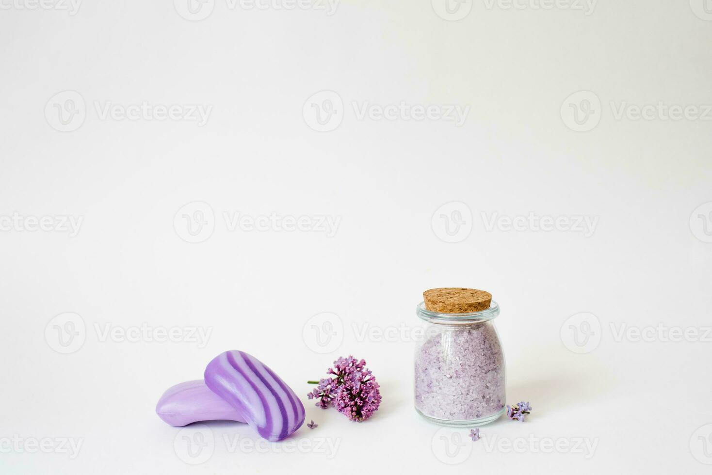 spa se soucier avec Naturel savon, mer sel, un gant de toilette gant pour corps se soucier, lilas fleurs et une bougie sur une lumière Contexte avec copie espace photo