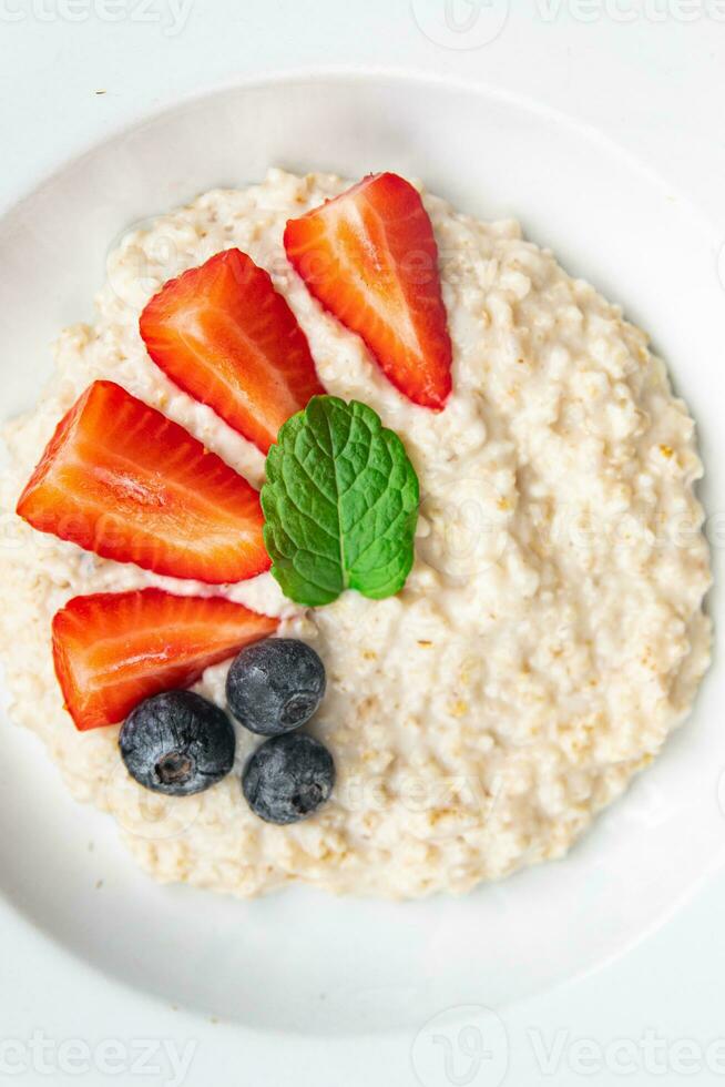 Frais flocons d'avoine petit déjeuner bouillie baies en bonne santé repas nourriture casse-croûte sur le table copie espace nourriture Contexte rustique Haut vue photo