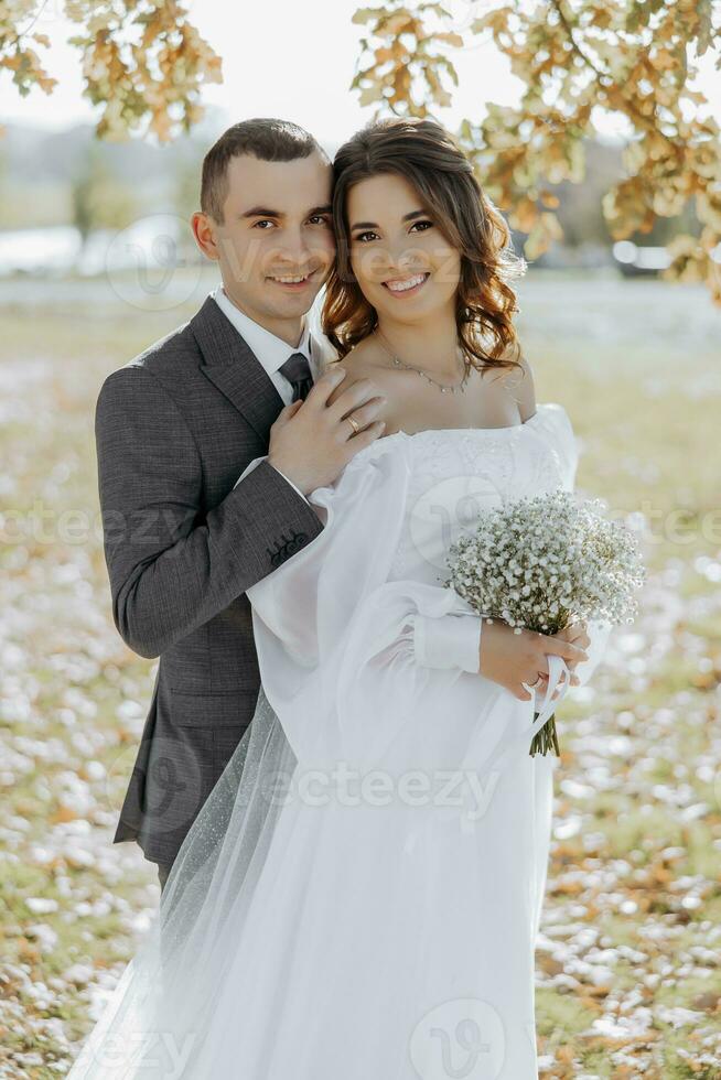 content mariage couple dans campagne. incroyable souriant mariage couple. jolie la mariée et élégant jeune marié. elle est content et enchanté. classique portrait de le la mariée et jeune marié. photo