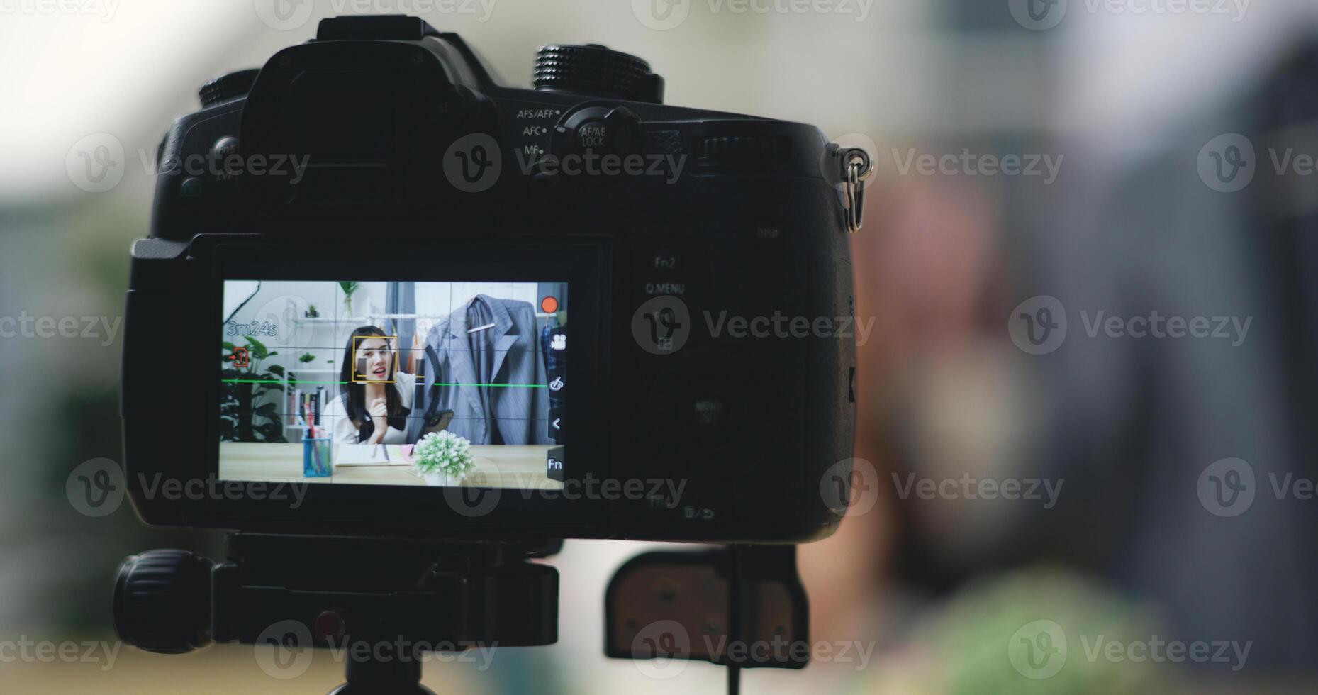 Jeune magnifique asiatique femme vivre diffusion à vêtements magasin sur numérique caméra photo