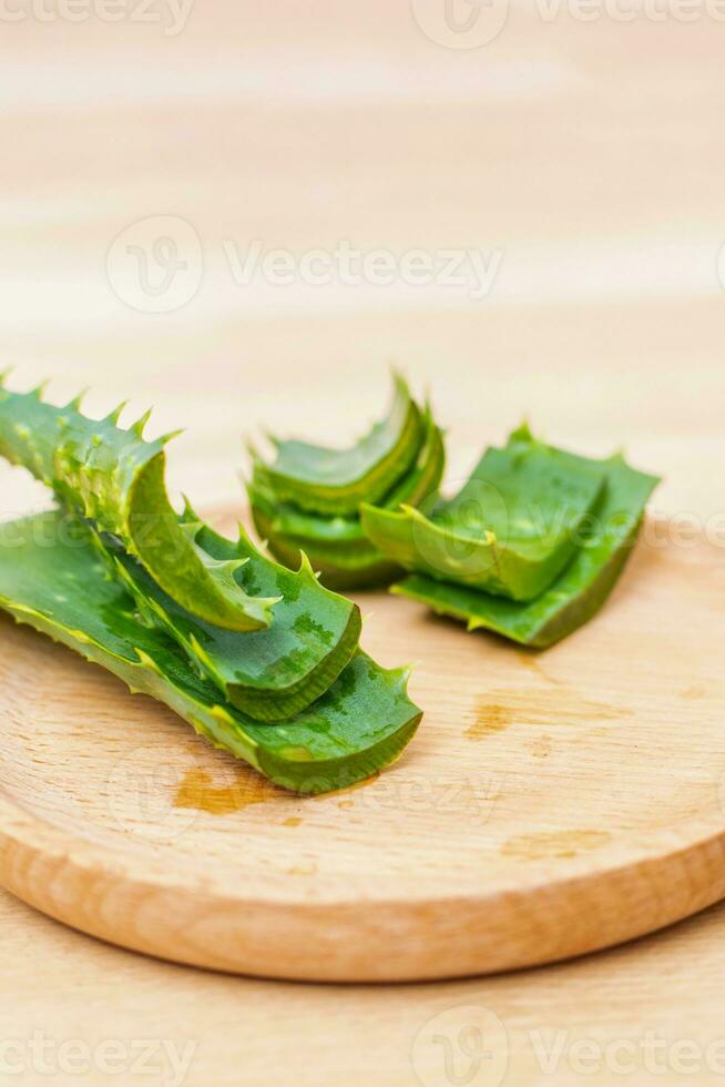 Frais aloès Vera feuilles et tranches de aloès Vera sur une en bois Contexte. photo