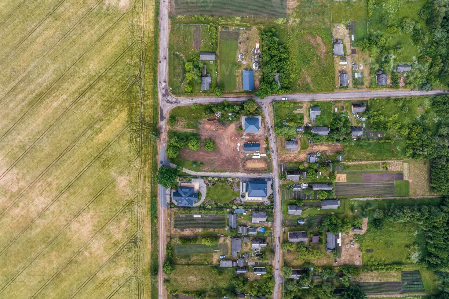 panoramique aérien vue de éco village avec en bois Maisons, gravier route, jardins et vergers photo