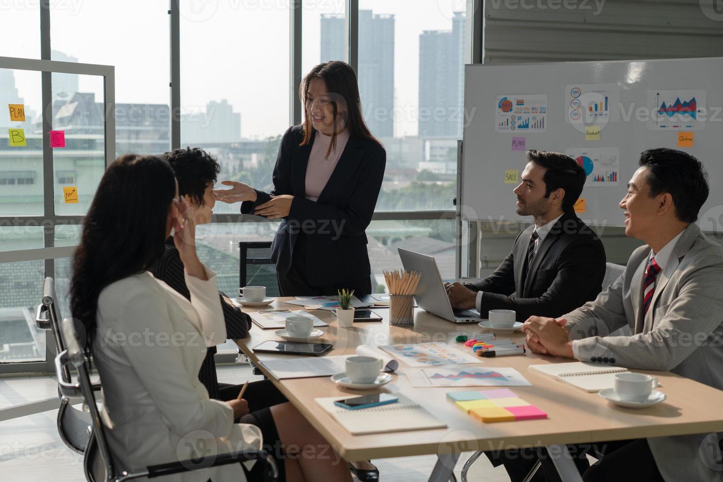 équipe commerciale multiethnique comprenant des personnes de race blanche et asiatique discutant d'un nouveau projet au bureau photo