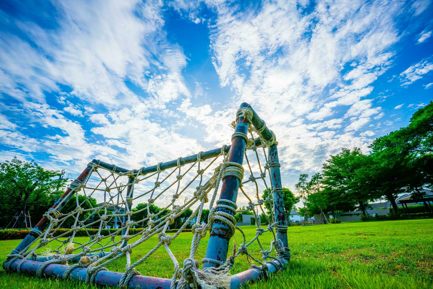 corde net but, mini football champ avec vert herbe simple, démodé miniature moustique filets tissé avec paille désordre en haut le parc ciel et blanc des nuages arrière-plan, sélectif se concentrer, doux se concentrer. photo