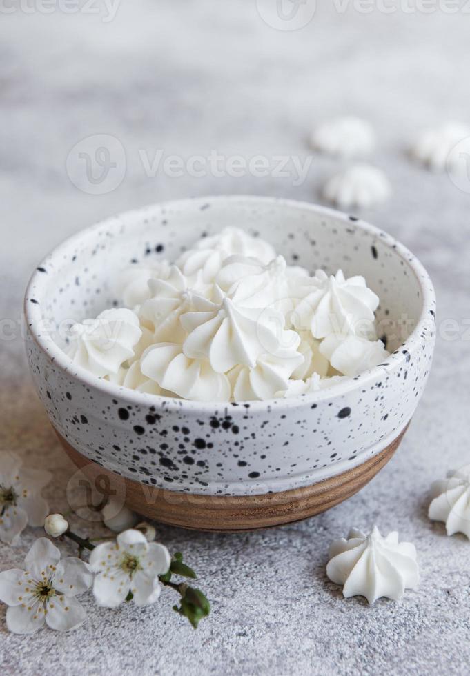 petites meringues blanches dans le bol en céramique photo