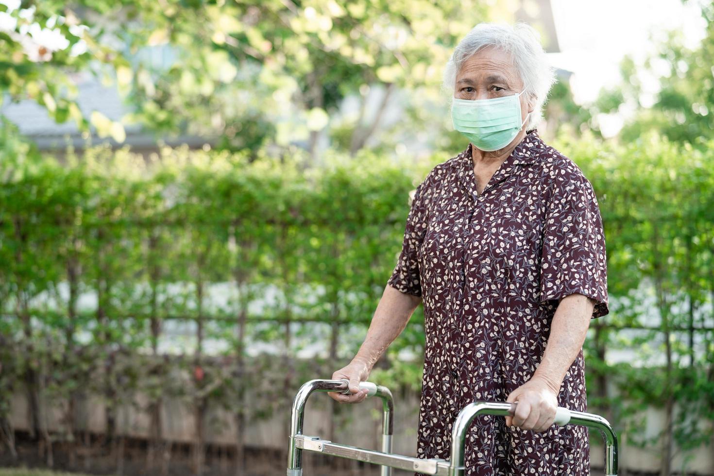 Asiatique senior ou vieille dame vieille femme patiente marche avec marcheur dans le parc avec espace de copie concept médical fort et sain photo
