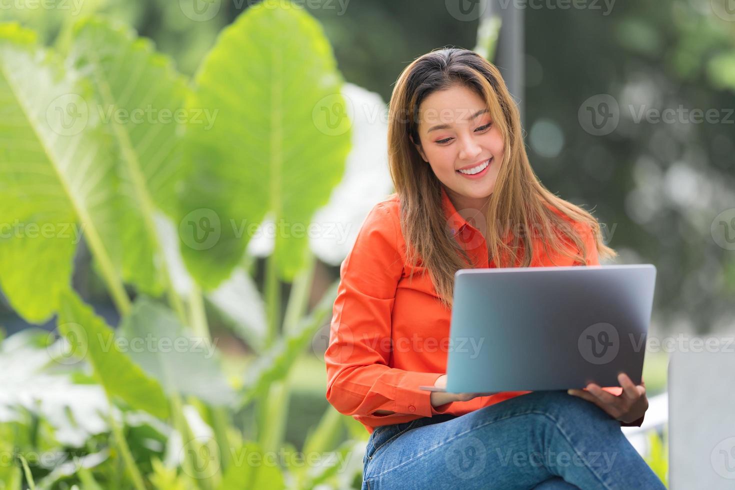 belle jeune femme à l'aide d'un ordinateur portable assis au parc du café photo