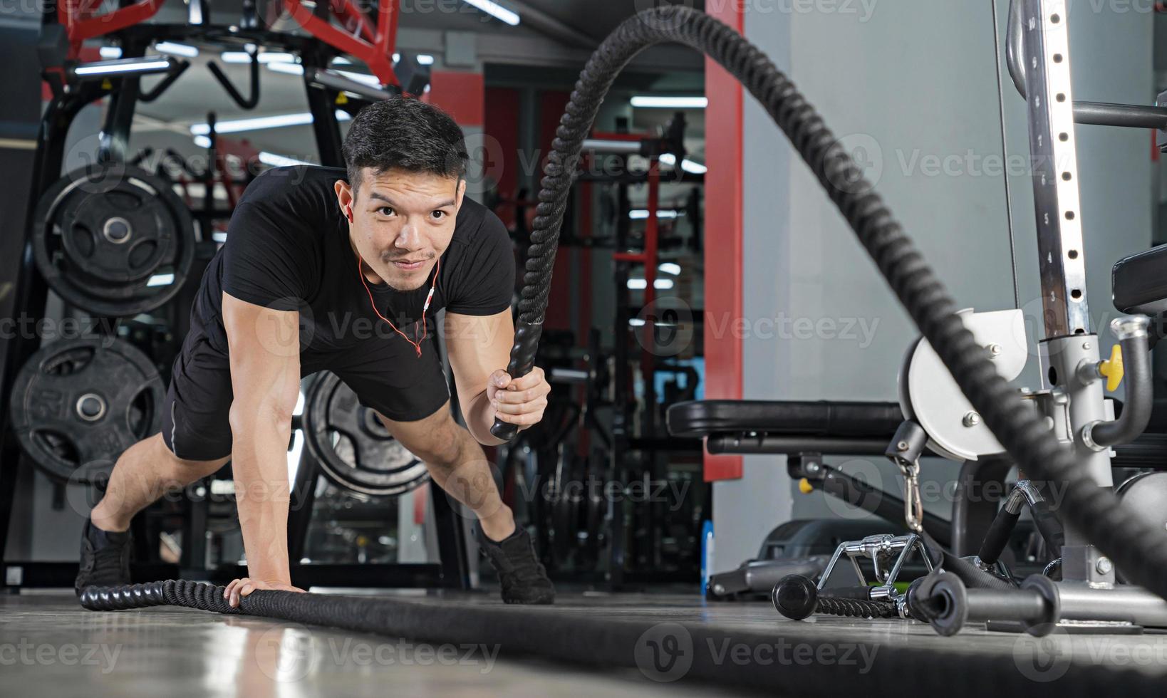 homme travaillant avec des cordes de combat au gymnase entraînement fonctionnel sport entraînement physique photo