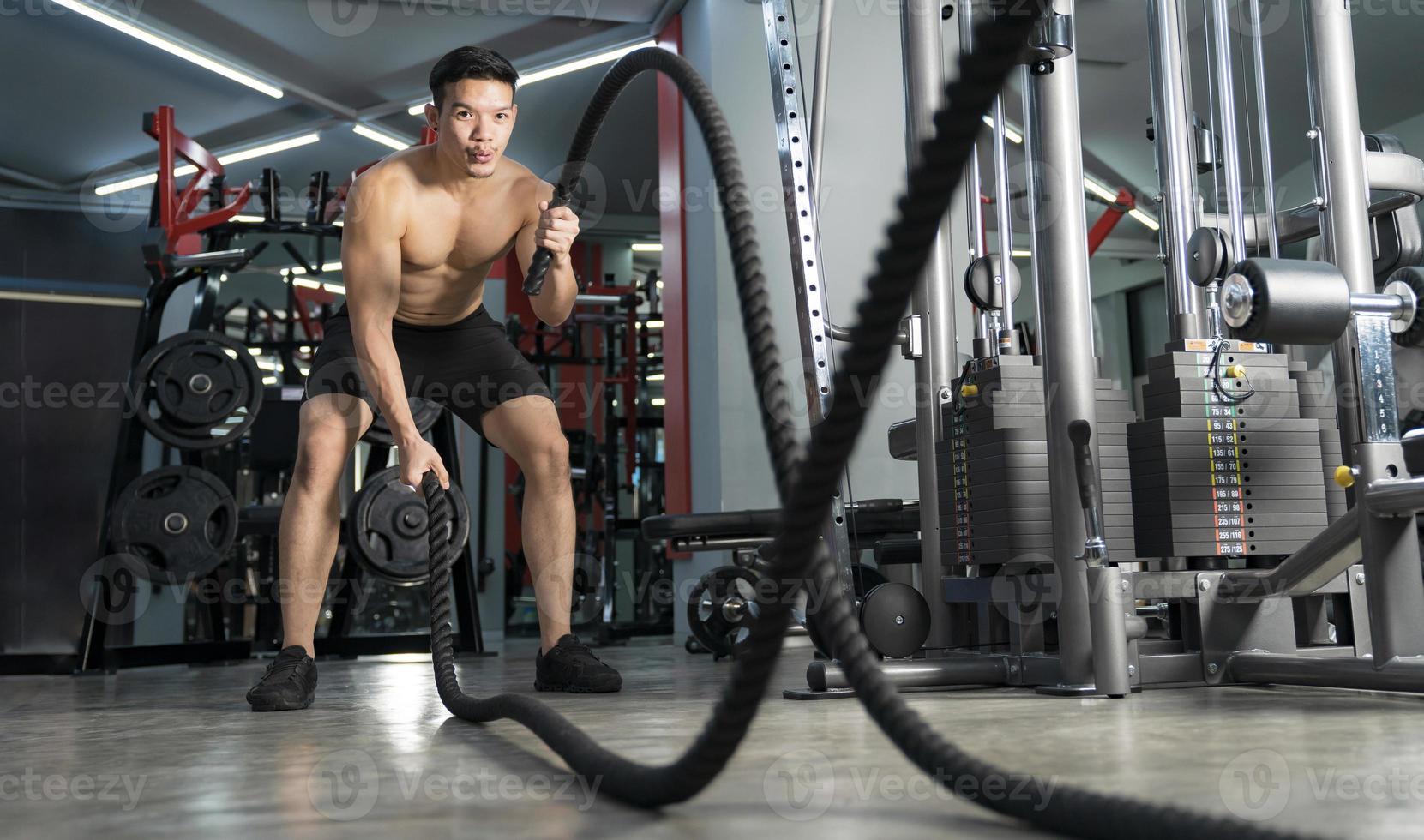 homme travaillant avec des cordes de combat au gymnase entraînement fonctionnel sport entraînement physique photo