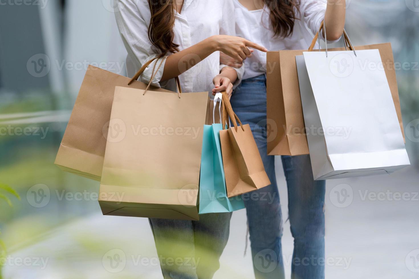Happy friends shopping deux jeunes femmes tiennent des sacs à provisions photo