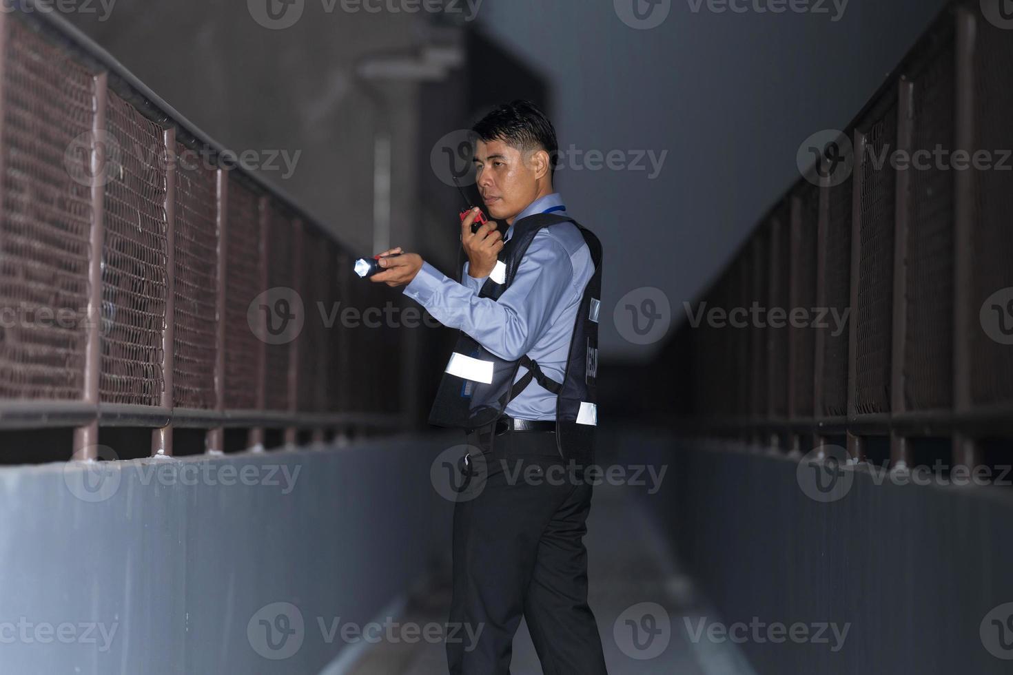 homme de sécurité debout à l'extérieur à l'aide d'une radio portable photo