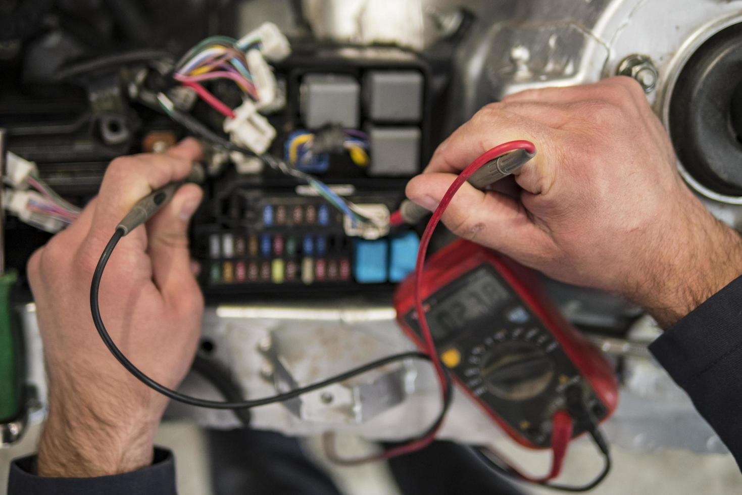 Un électricien automobile répare un testeur de voiture, des fusibles et des pinces photo