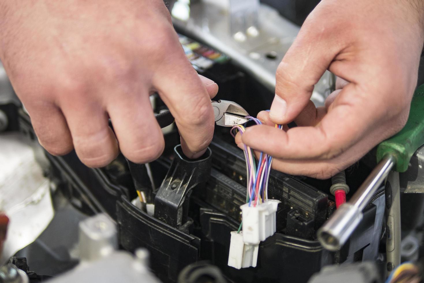 Un électricien automobile répare un testeur de voiture, des fusibles et des pinces photo