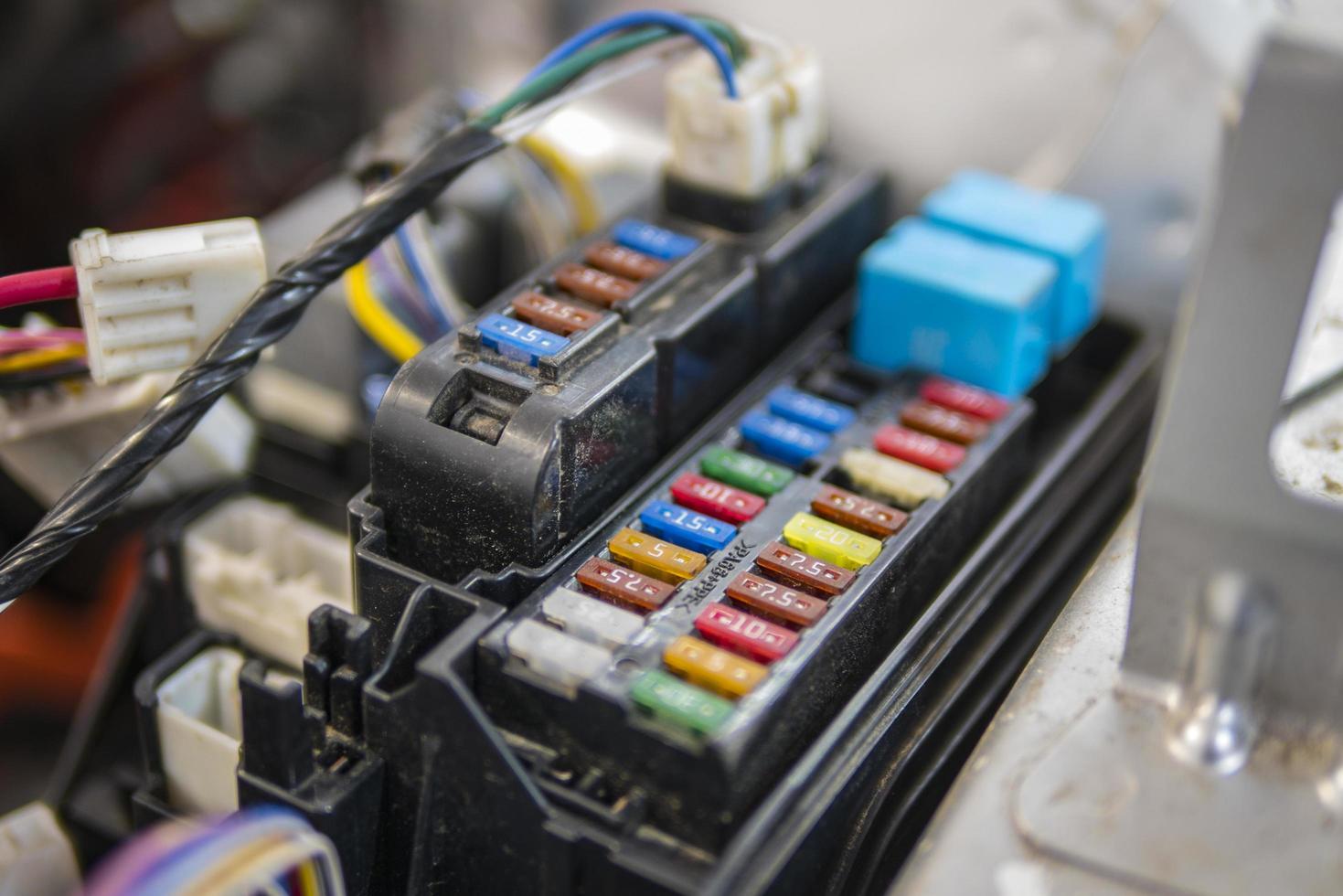 Un électricien automobile répare un testeur de voiture, des fusibles et des pinces photo