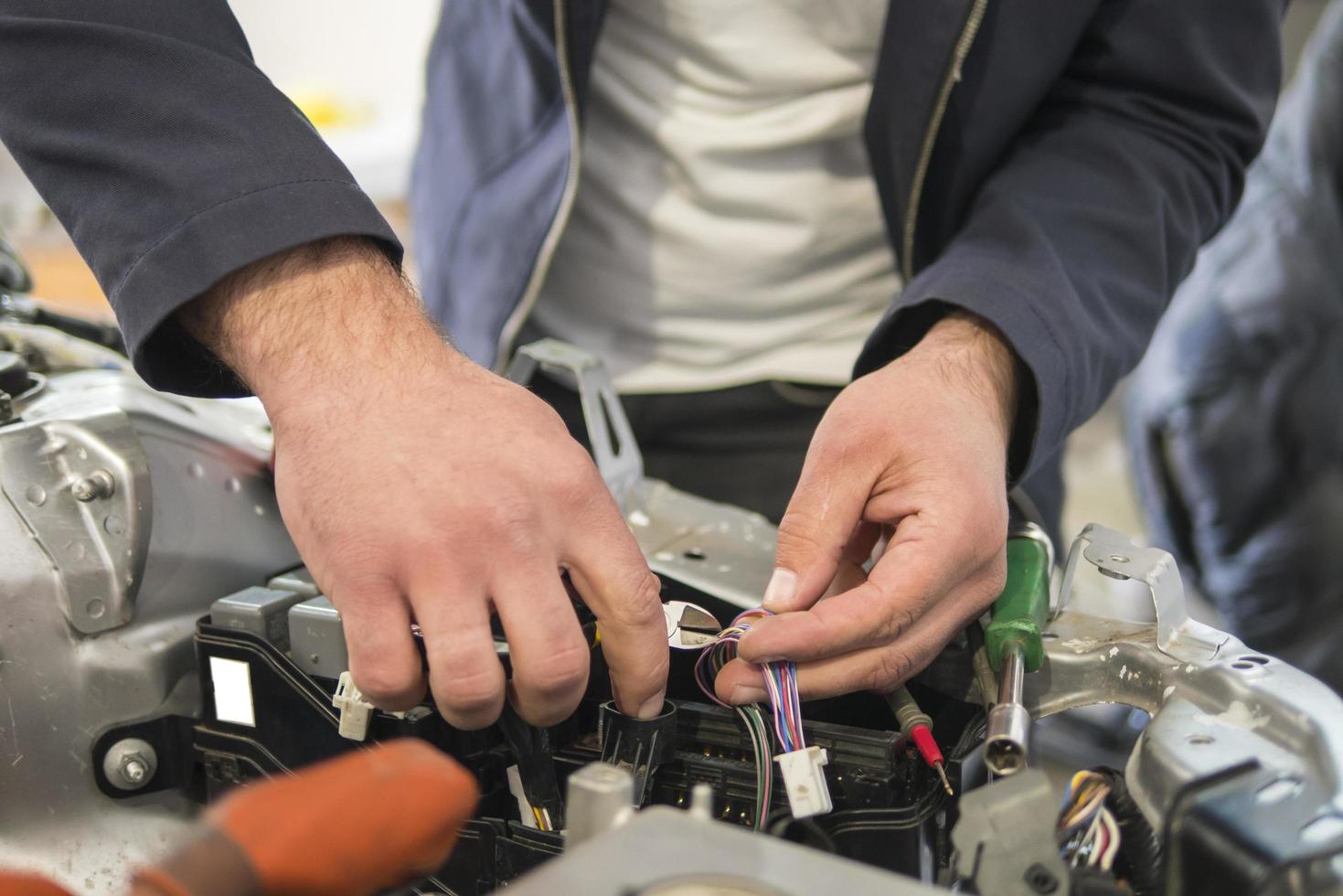 Un électricien automobile répare un testeur de voiture, des fusibles et des pinces photo