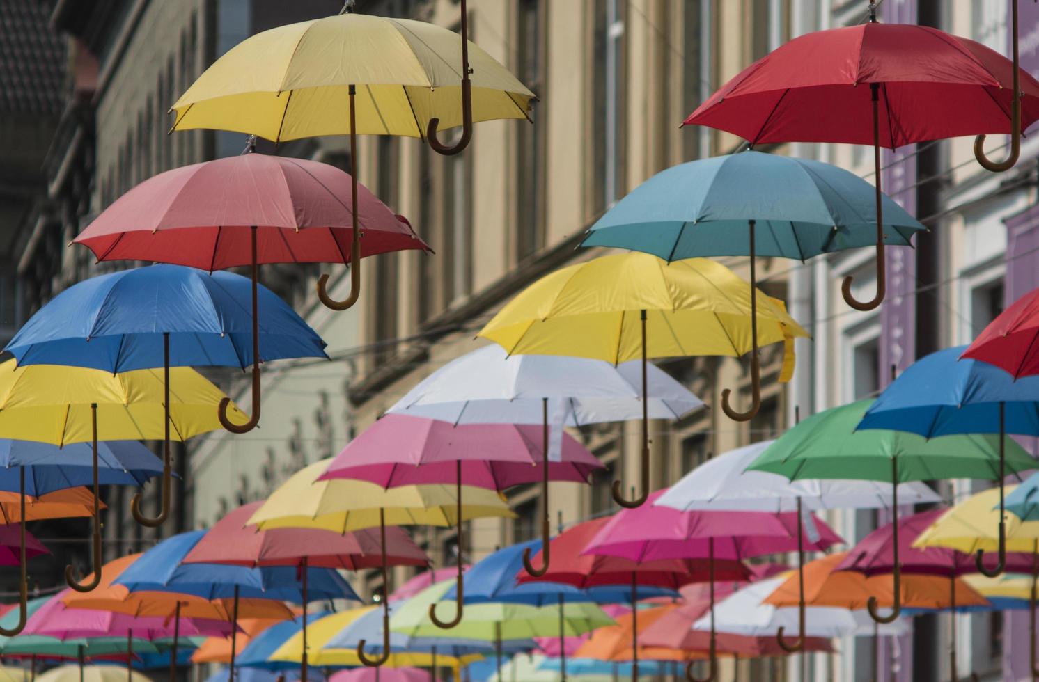 des parapluies colorés sont accrochés au fond de la vieille ville de lviv photo