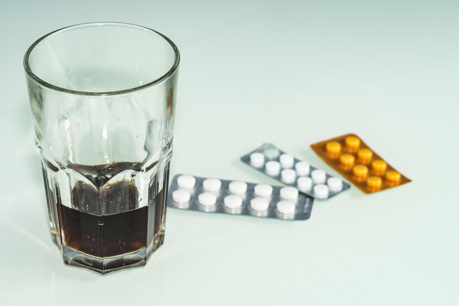 des pilules sont éparpillées sur la table un traitement au whisky ou au rhum ou au suicide photo