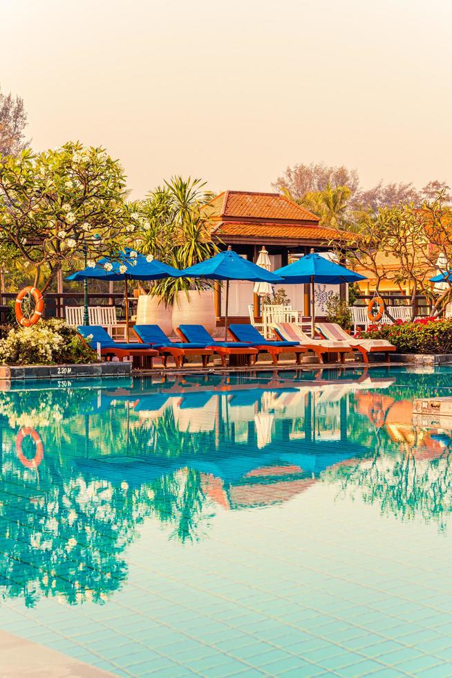 beau parasol et chaise autour de la piscine de l'hôtel et du complexe photo