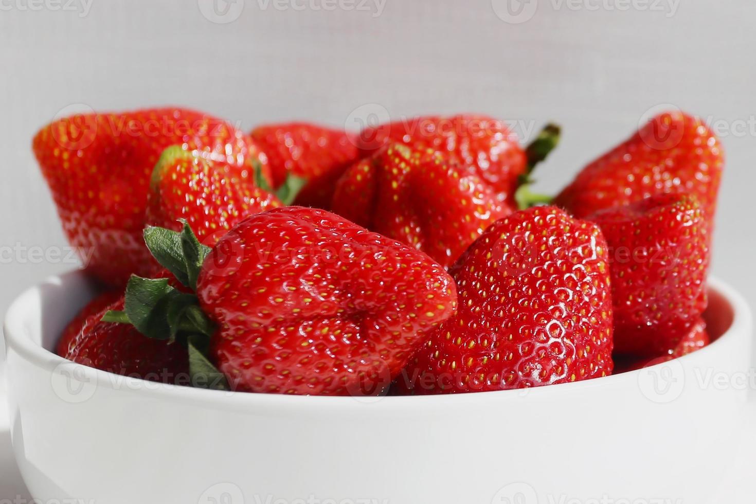 fraises fraîches dans un bol sur fond blanc photo