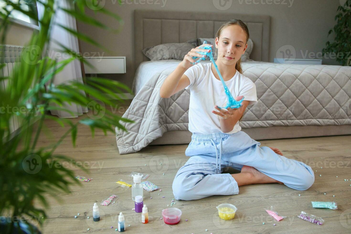 une adolescent est en jouant avec une bleu vase. concept de fille fabriqué fait maison gelée. photo
