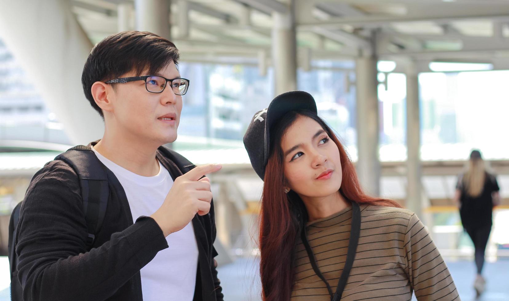 un couple de touristes asiatiques et voyageant joyeusement dans la ville photo