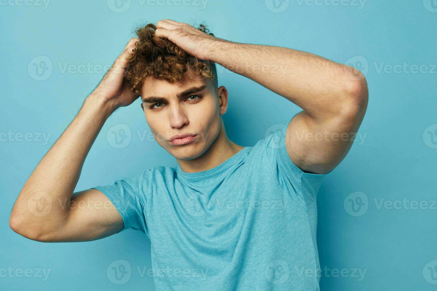 Beau gars dans bleu t-shirts avec une gonflé à bloc corps isolé Contexte photo