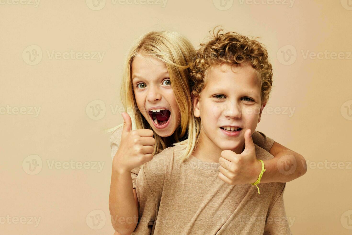 garçon et fille dans beige t-shirts posant pour amusement enfance inchangé photo