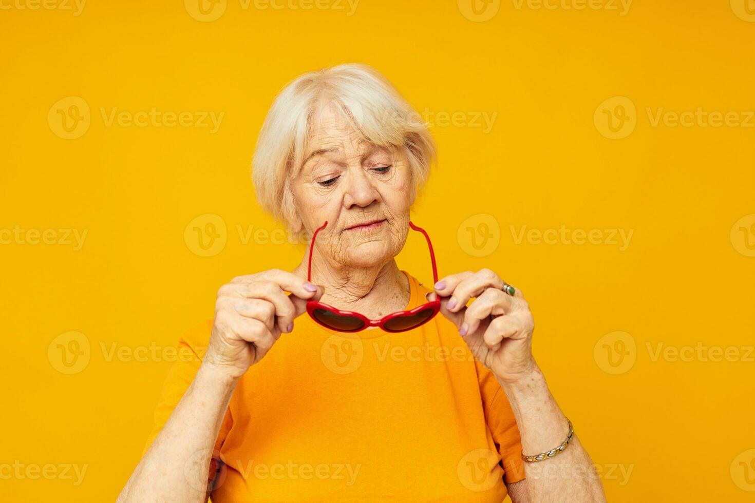 photo de retraité vieux Dame dans foncé des lunettes dans le forme de une cœur  Jaune Contexte 25016404 Photo de stock chez Vecteezy