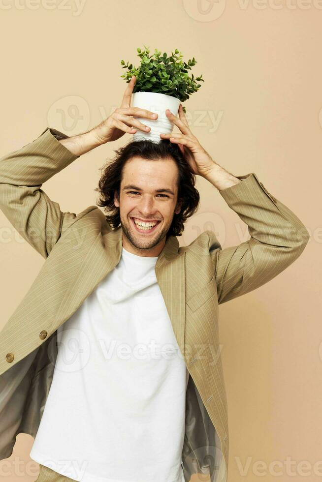 attrayant homme avec une fleur pot dans le sien mains classique style isolé Contexte photo