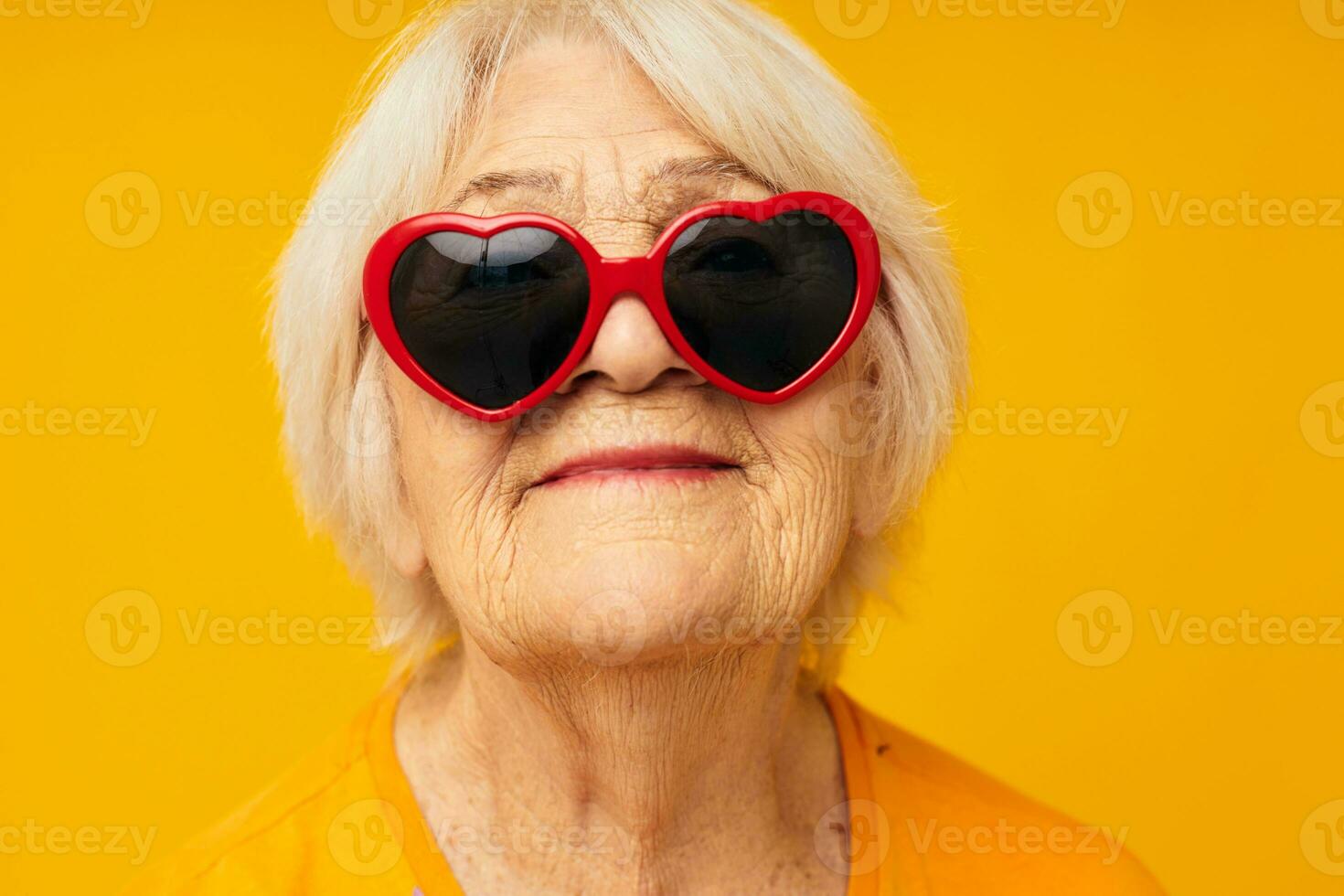 photo de retraité vieux Dame dans foncé des lunettes dans le forme de une cœur  Jaune Contexte 25016404 Photo de stock chez Vecteezy