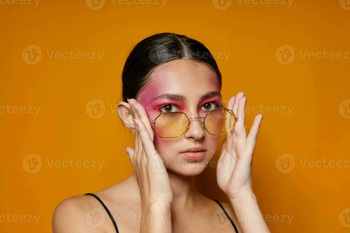 Jeune magnifique femme mode des lunettes rose visage maquillage posant attrayant Regardez isolé Contexte inchangé photo