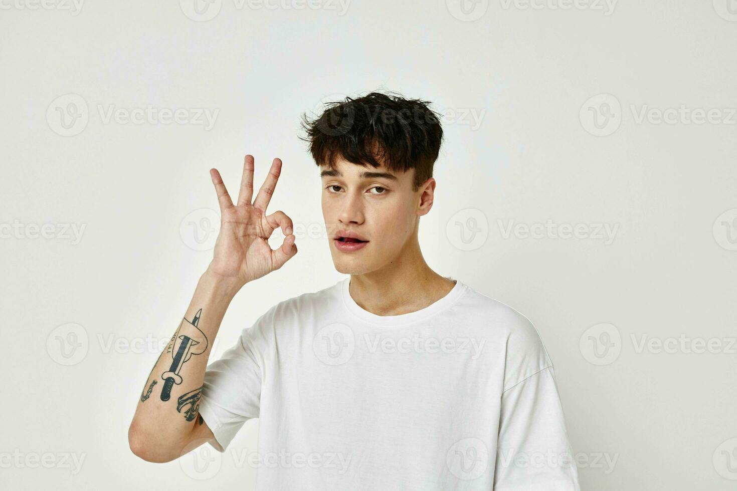 portrait de une Jeune homme moderne jeunesse style blanc T-shirt tatouage sur le bras modèle studio photo