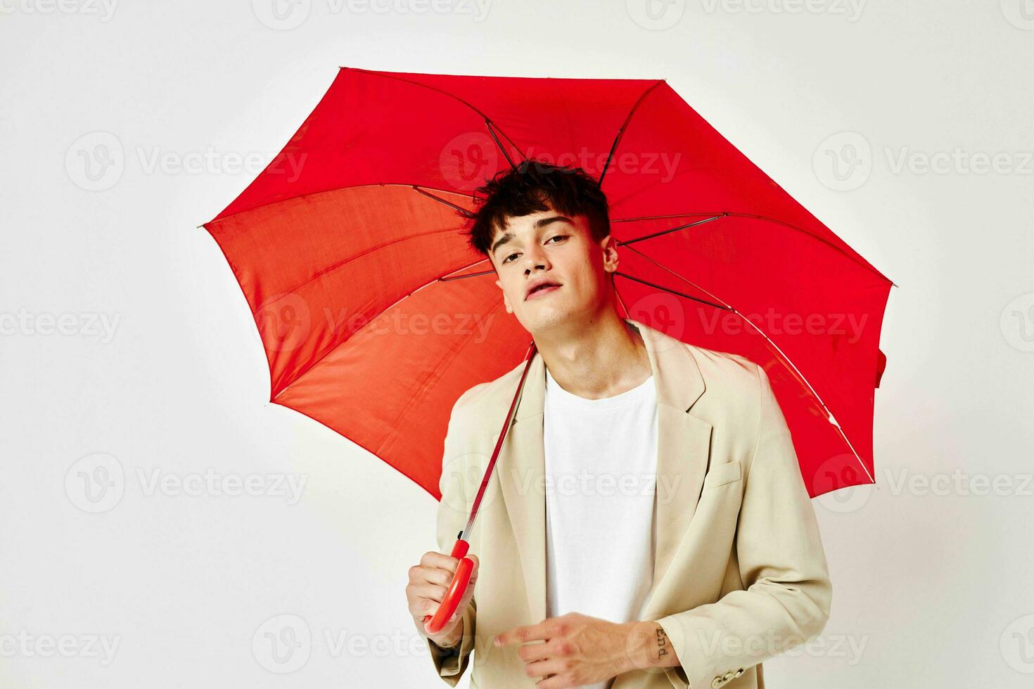 une Jeune homme rouge parapluie une homme dans une lumière veste isolé Contexte inchangé photo