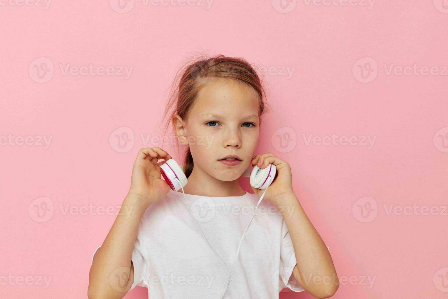 portrait de content souriant enfant fille dans une blanc T-shirt avec écouteurs enfance inchangé photo