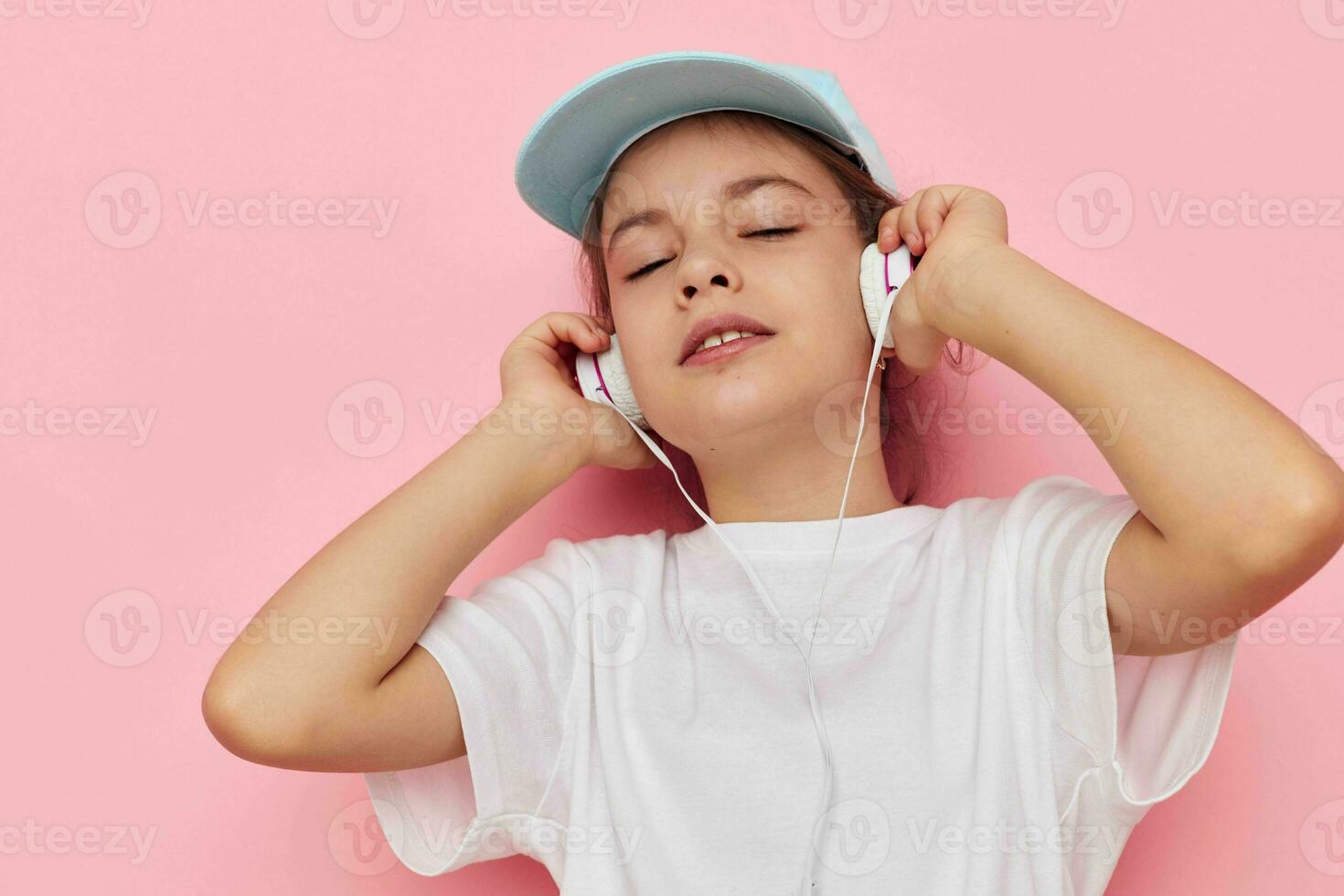 peu fille écoute à la musique sur écouteurs isolé Contexte photo