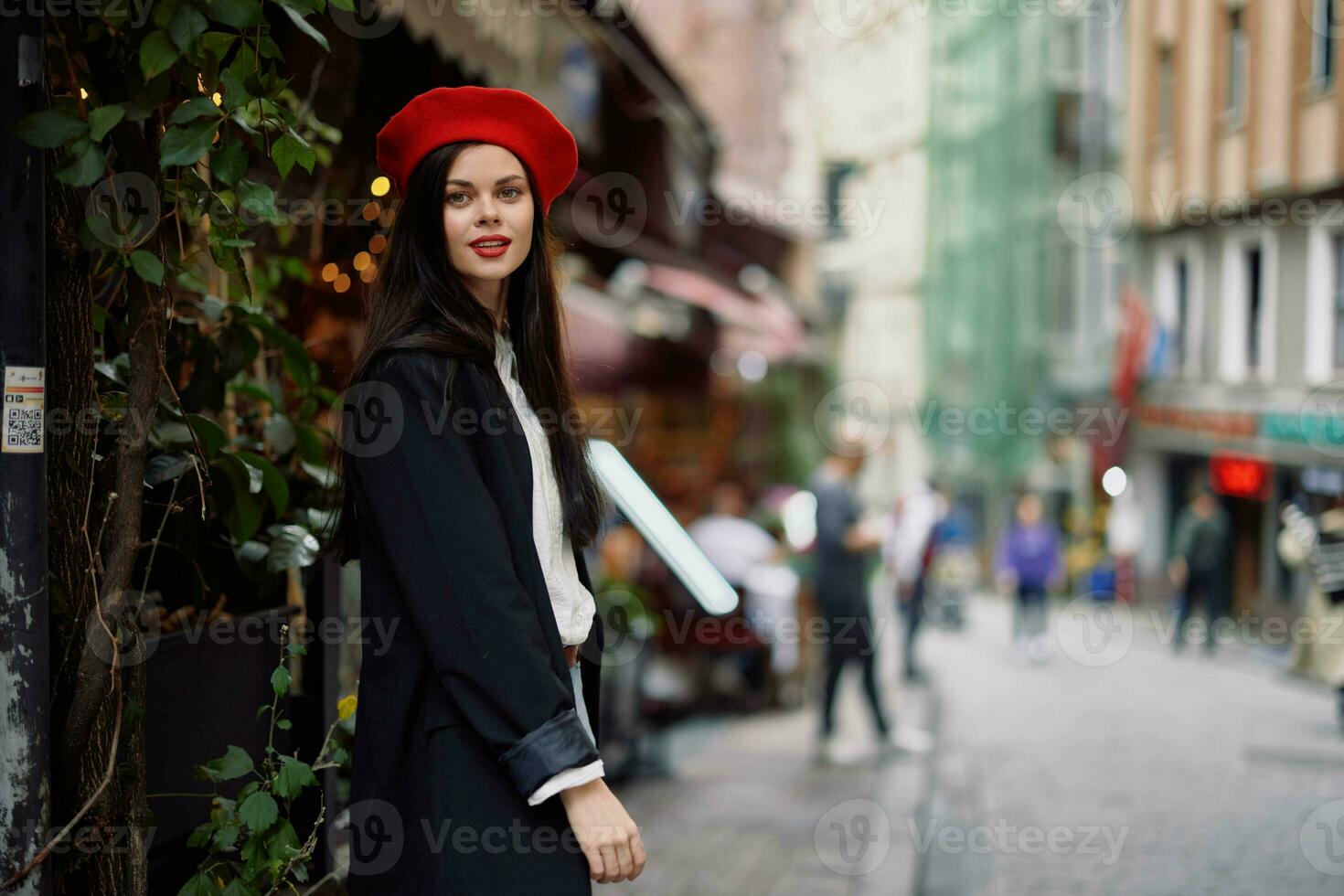 femme sourire mode modèle des promenades sur le rue dans le ville centre parmi le foule dans une veste et rouge béret et jeans, cinématique français mode style vêtements, Voyage à Istanbul photo