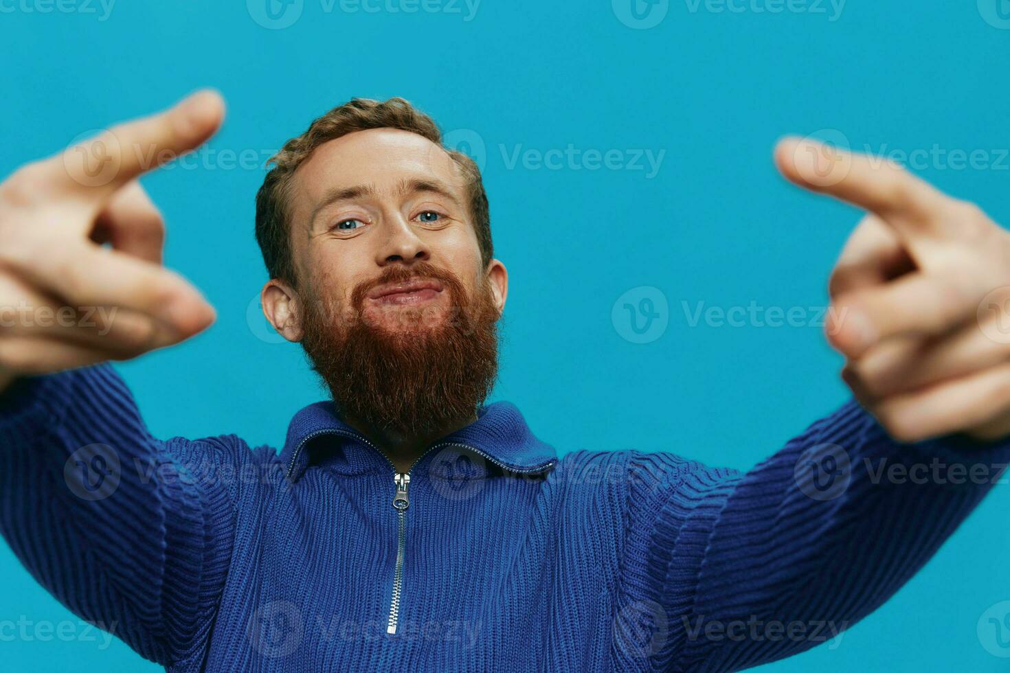 portrait de une homme dans une chandail sourire et bonheur, main panneaux et symboles, sur une bleu Contexte. mode de vie positif, copie lieu. photo