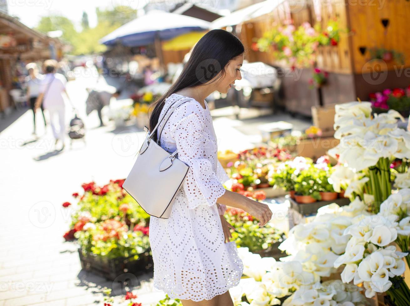 Jeune femme achetant des fleurs au marché aux fleurs photo