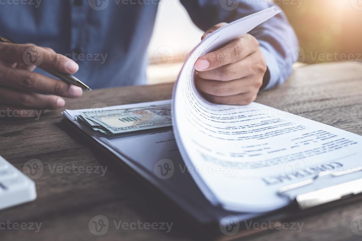 homme d'affaires avec document contractuel et dollars sous le document photo