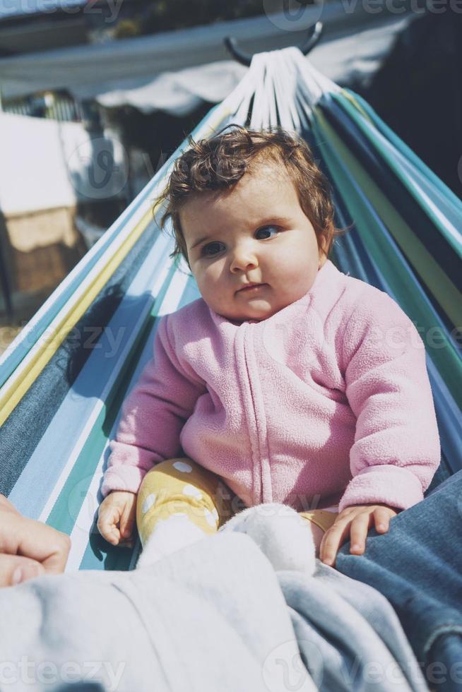 petit bébé s'amusant sur un hamac par une journée ensoleillée photo