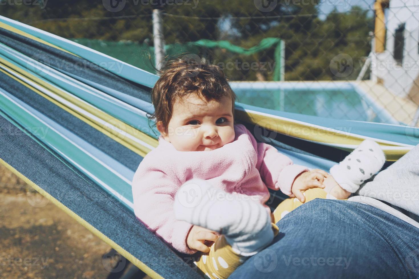 petit bébé s'amusant sur un hamac par une journée ensoleillée photo