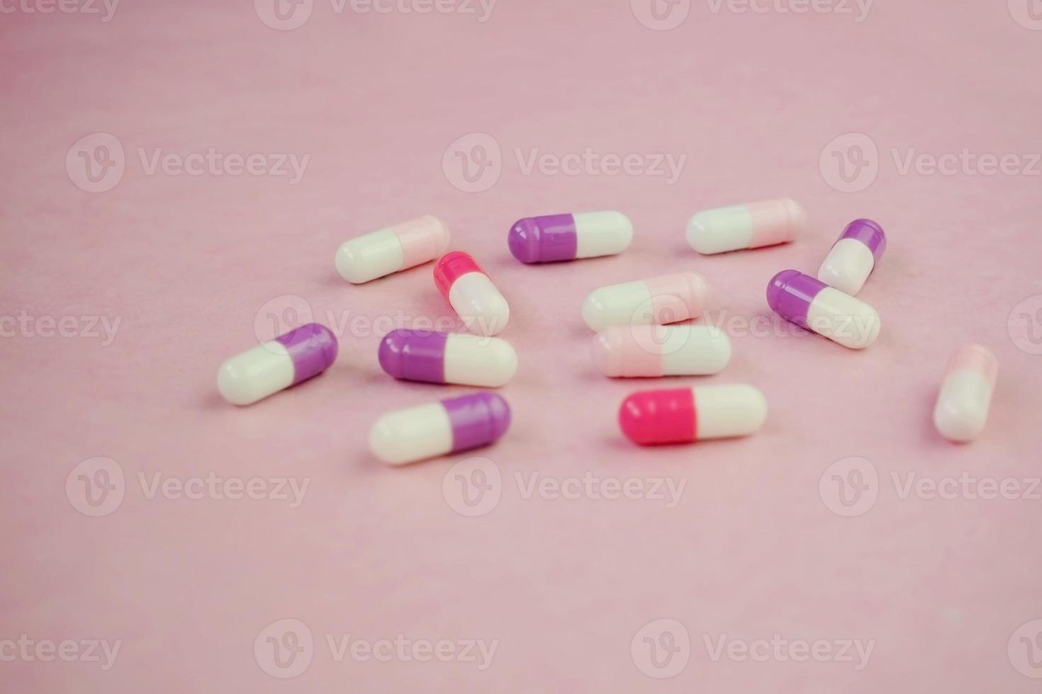 une macro détaillée de pilules et capsules avec fond rose photo