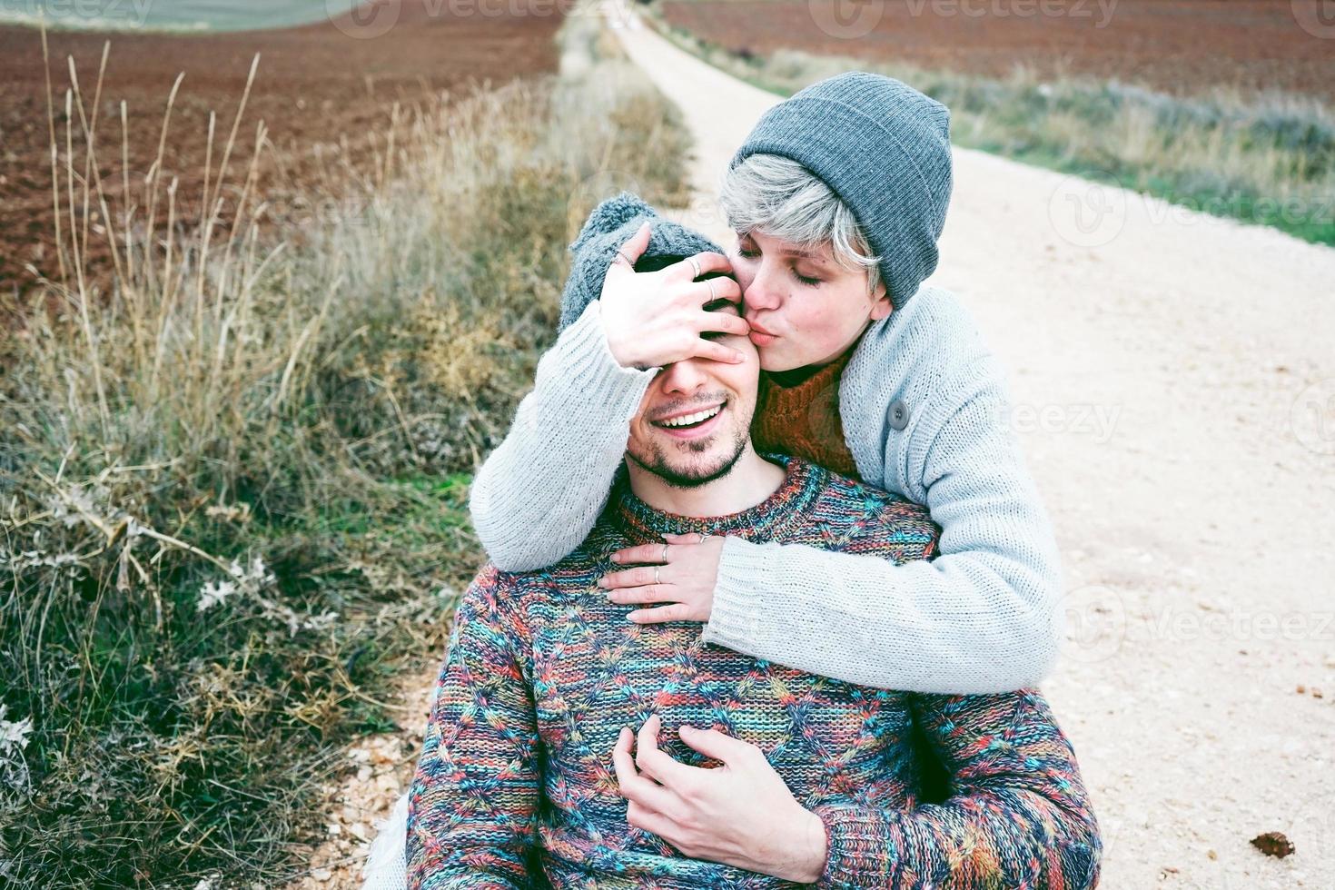 couple de jeunes millénaires étreignant et souriant dans un voyage d'aventure sur un chemin de campagne en plein air photo