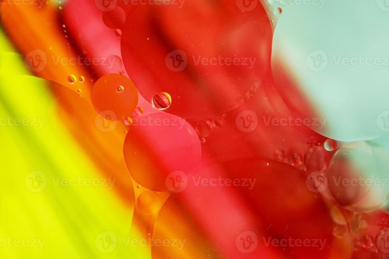 une belle macro colorée de bulles d'huile sur l'eau avec une texture à rayures jaune, rouge, verte, orange et bleue comme motif de fond photo